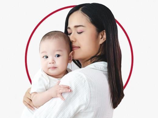 Ruam Popok karena Infeksi Jamur: Gejala & Pengobatan | Canesten - Wanita yang menggendong bayi dalam pelukannya dengan gembira setelah perawatan ruam popok dari Canesten