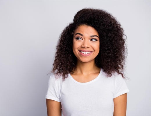 wanita dengan baju putih tersenyum setelah perawatan dengan krim canesten